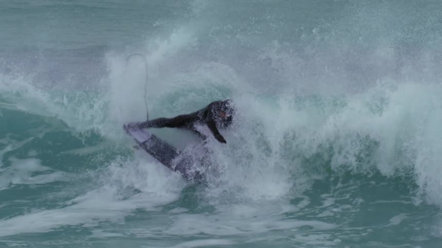 Man surfer doing a radical maneuver on a wave