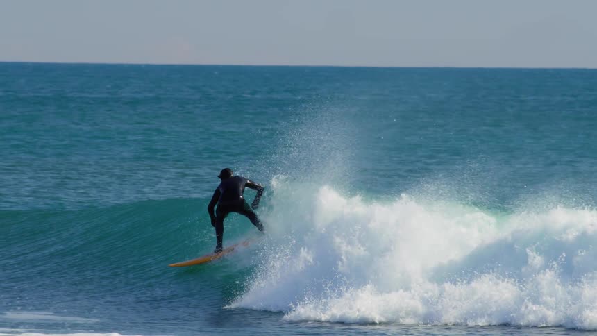 Man dropping into a wave and practicing maneuvers