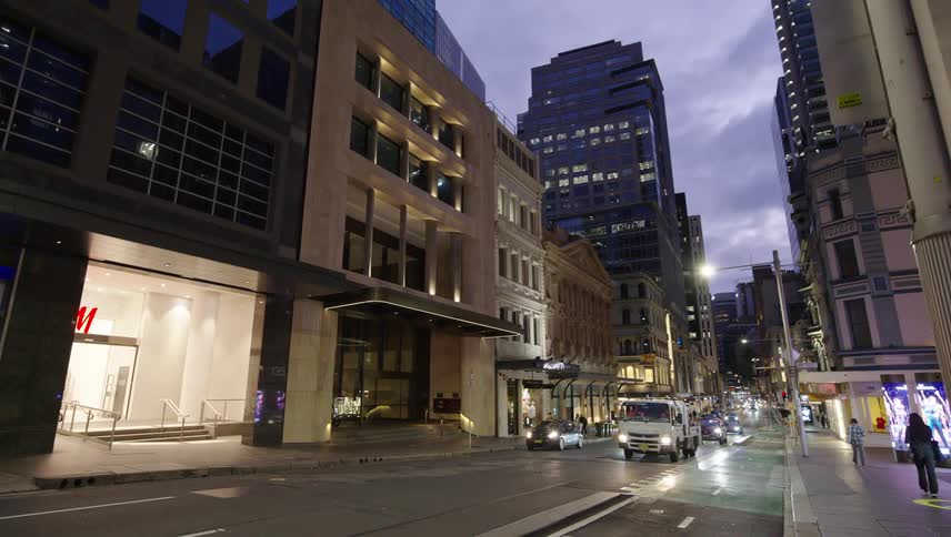 Street with vehicle traffic in a metropolis in the early evening