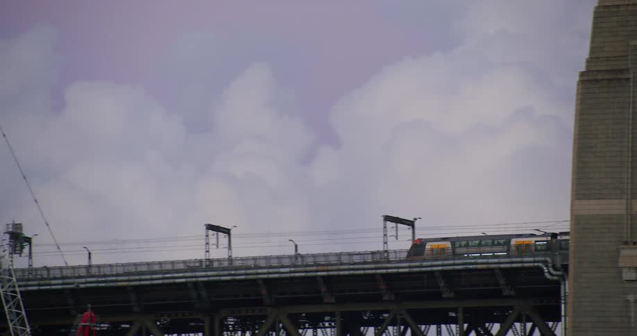 Train moves over bridge on a cloudy day