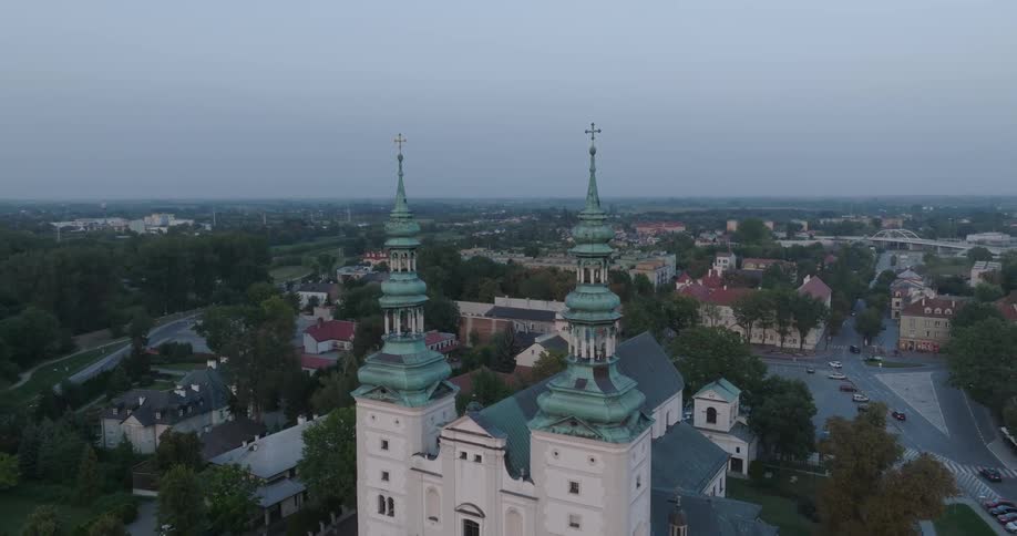 A large and old church sits near streets and suburban buildings in a city