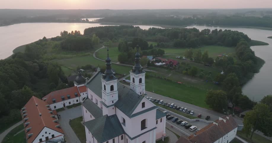 Aerial view of a monastery on a land surrounded by greenery and by the sea