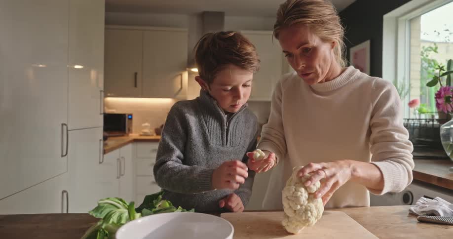 Mother and son cooking together in the kitchen at home