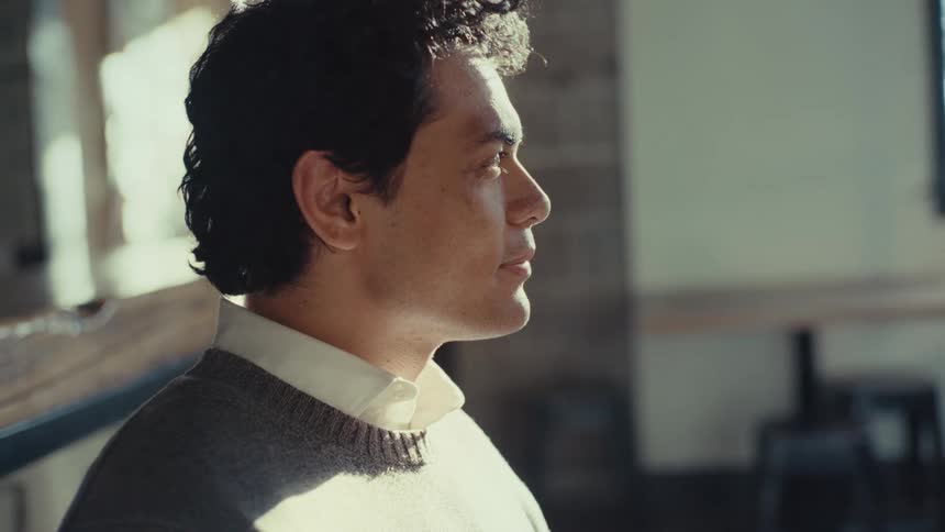 Man sitting indoors next to another person