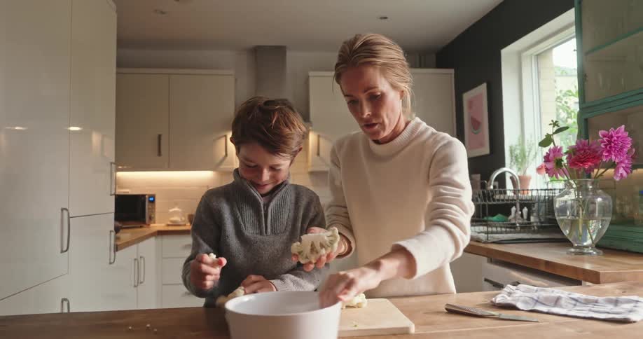 Mother and son cooking together in the kitchen at home