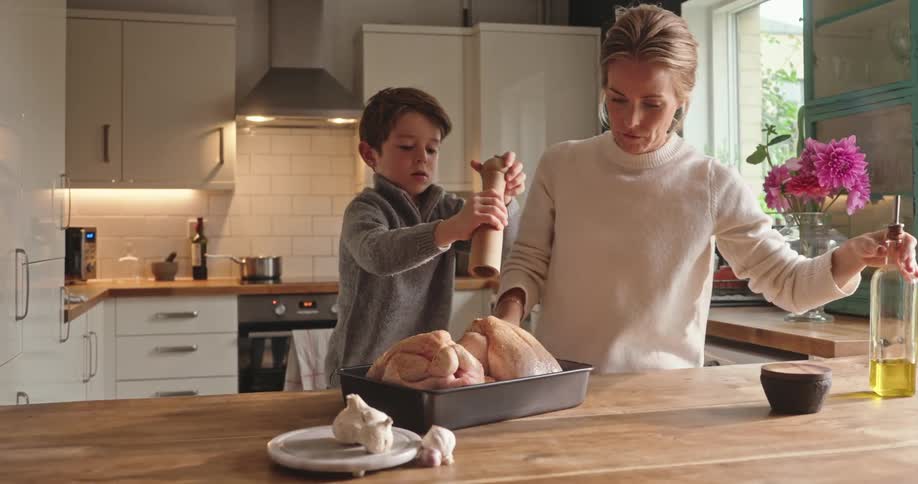 Mother and son cooking together in the kitchen at home