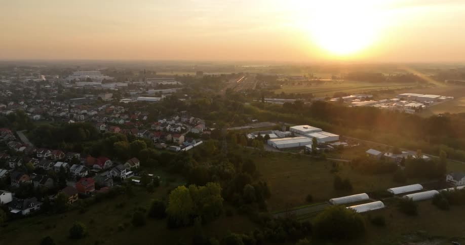 A bright sun in the sky illuminates a town as well as nature