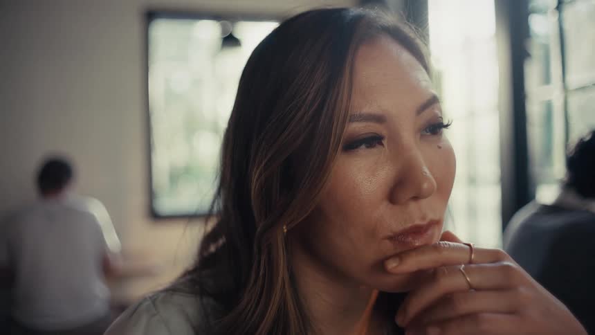 A female worker in an office sits and thinks deeply