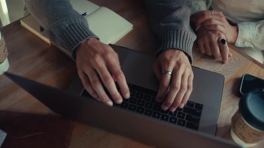 Hands of a man typing and then a woman starts typing