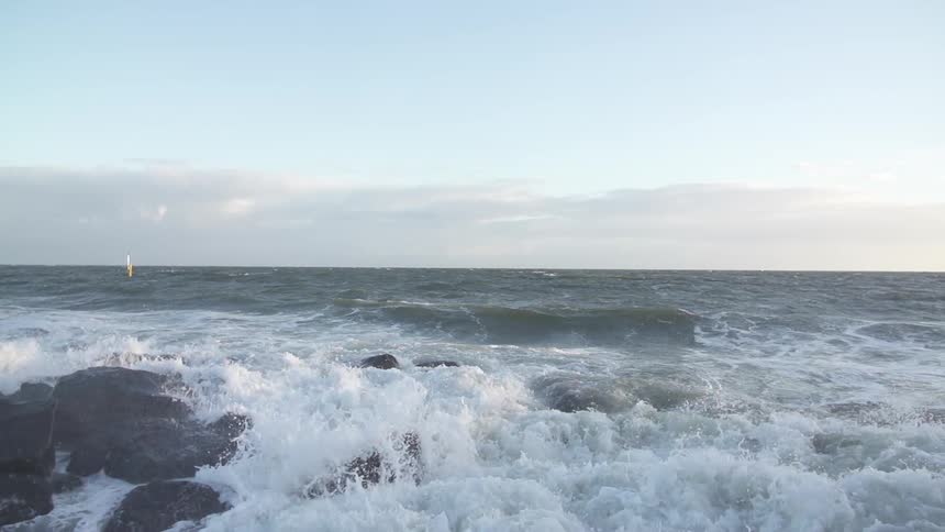 Waves crash on rocks in the day time