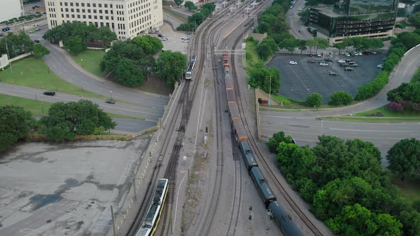 An aerial view of trains crossing a bridge over a highway