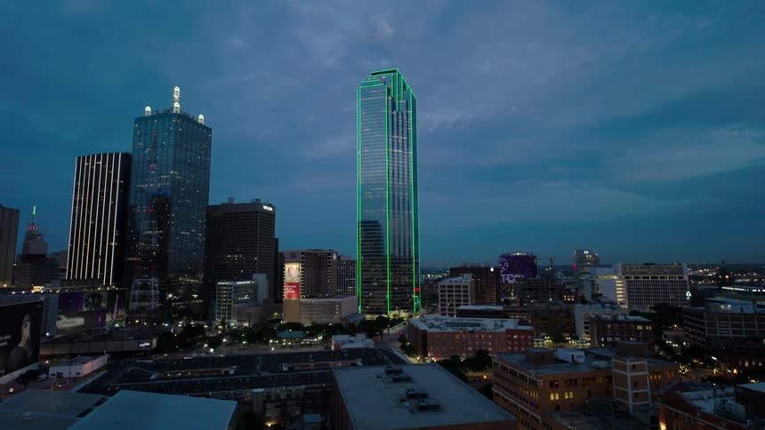 Aerial panorama of a metropolis with modern skyscrapers illuminated in the early evening