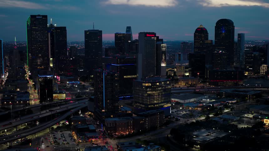 City skyline at dusk with several illuminated skyscrapers