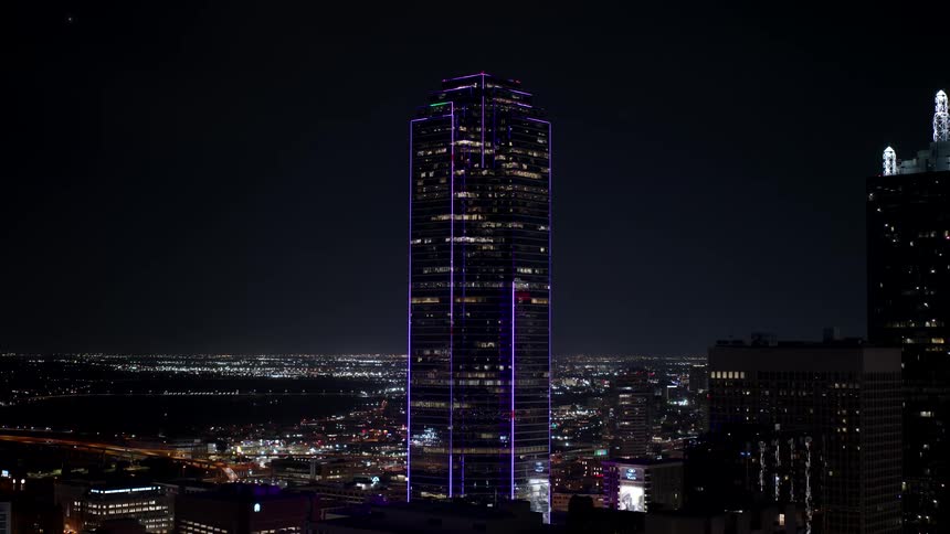 A skyscraper is lit up at night