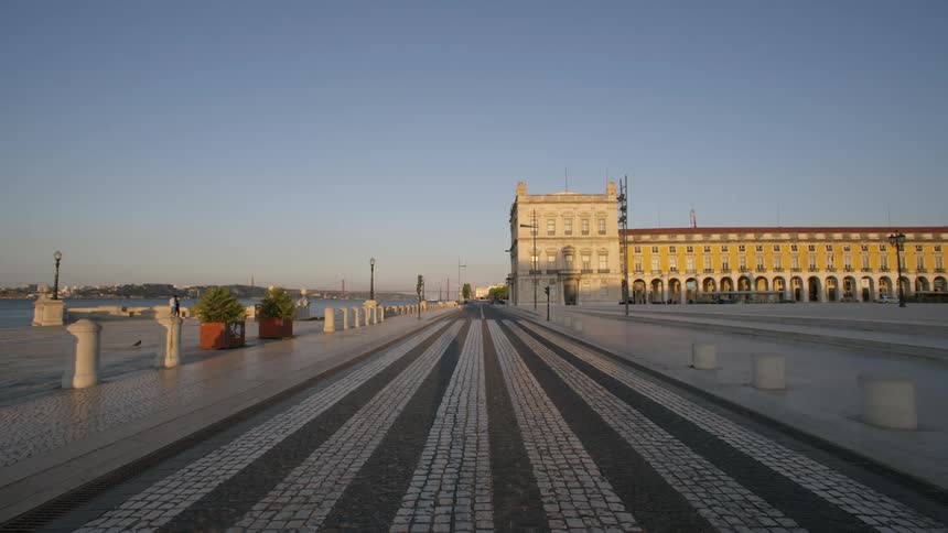 Cobblestone square by the sea with a classic building in the background seen in the morning
