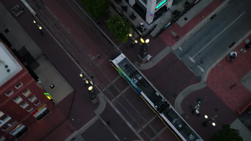 Top view of a train passing between buildings in a city