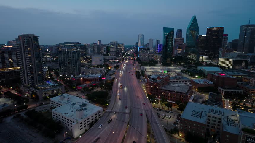 Aerial view of a highway with traffic and buildings of a metropolis around it
