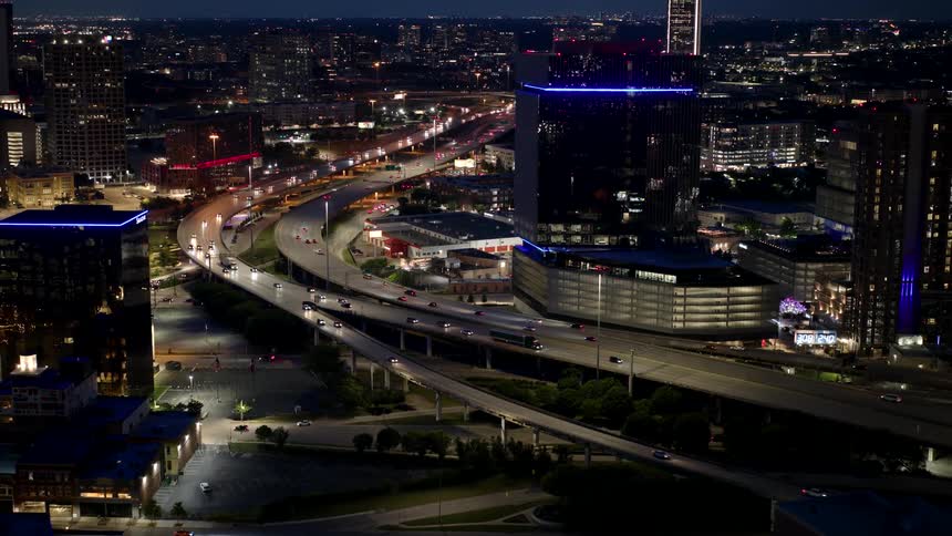 Nighttime cityscape with illuminated buildings and busy streets