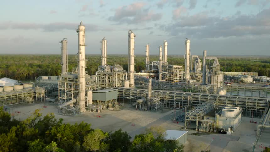 Aerial view of a large refinery surrounded by trees