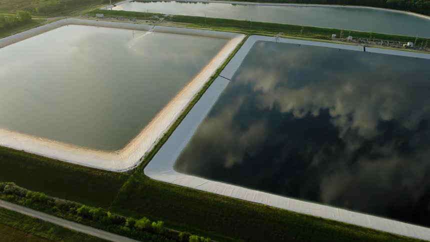 Aerial view of two water reservoirs reflecting the sky with clouds