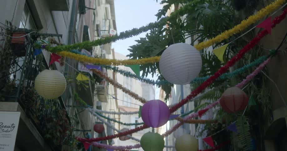 Alley between residential buildings decorated with colorful festive lights