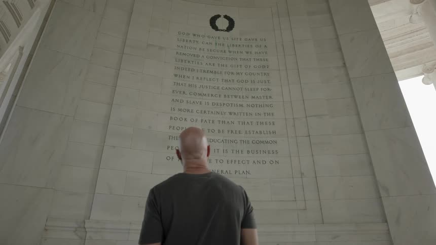 Man reading a scripture in a building with classical architecture