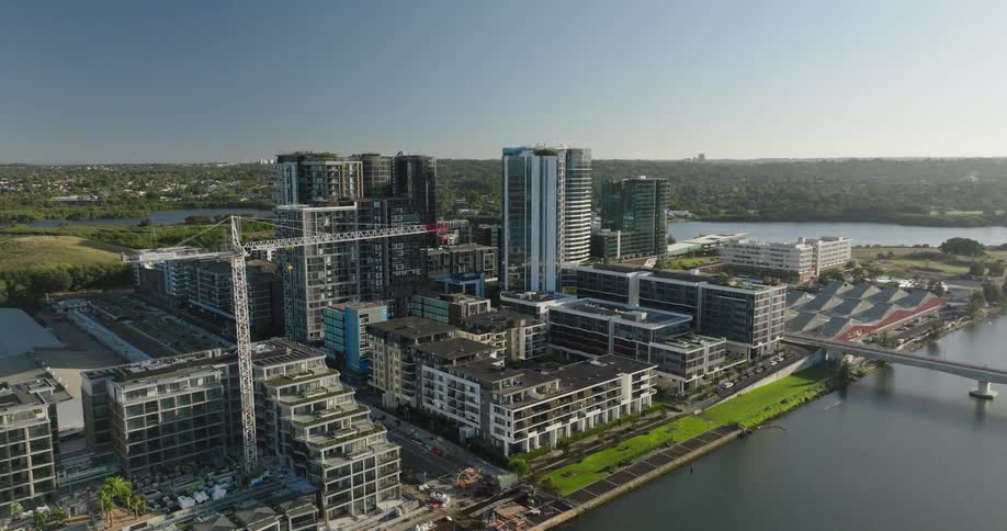 Modern urban landscape with highrise buildings under construction beside a body of water