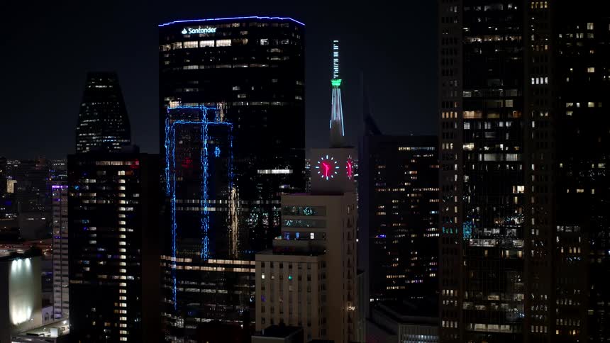 Aerial view of a nighttime cityscape with illuminated skyscrapers