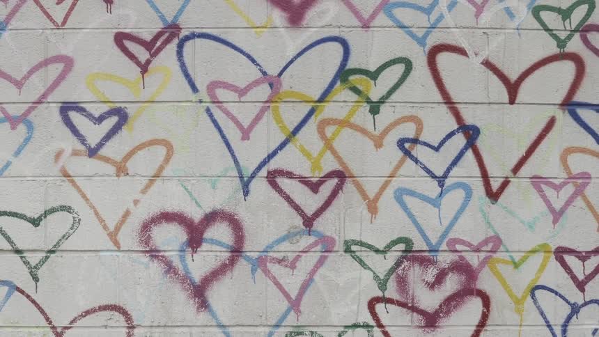 Wall with several hearts drawn in different sizes and colors