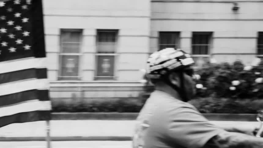 Moving view of an urban city and a passing motorcycle with the us flag