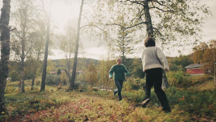 Two women running through a forested area