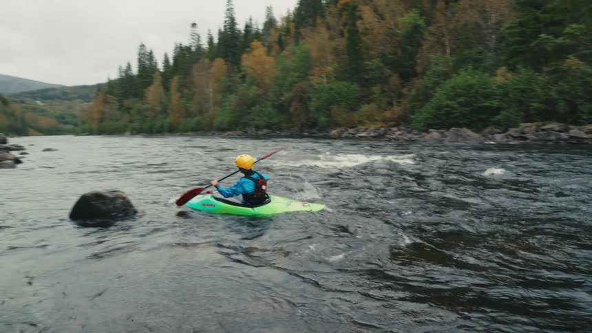 Person kayaking in a river with rapids