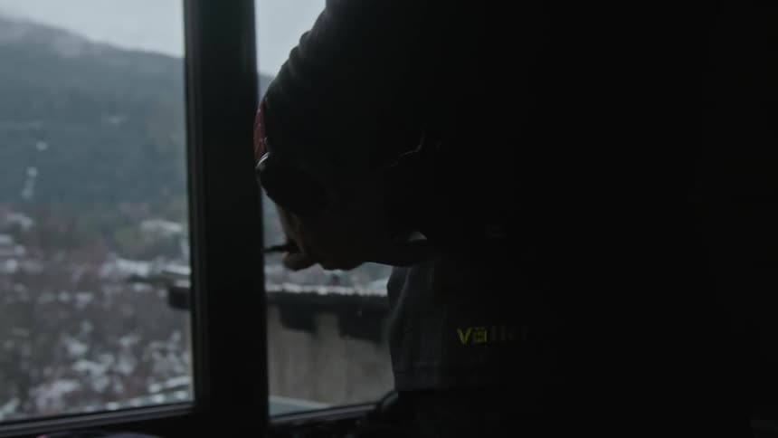 A man puts his device away by the window