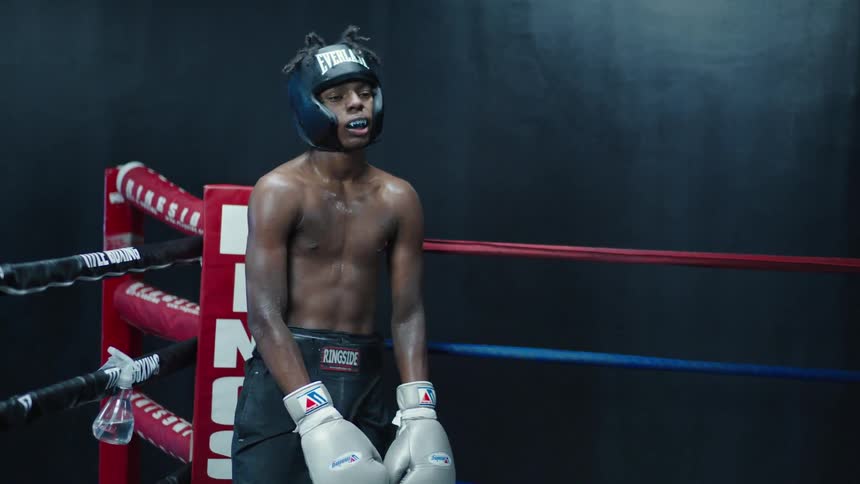 Sweaty tired male boxer stands in a boxing ring
