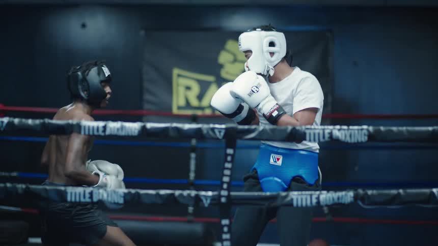Two men fighting inside a boxing ring and shaking hands at the end