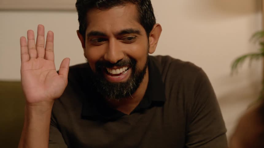 Man high fives with woman happily in living room at night