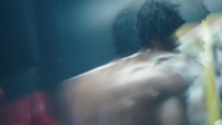 Two boxers spar in a boxing ring in a gym