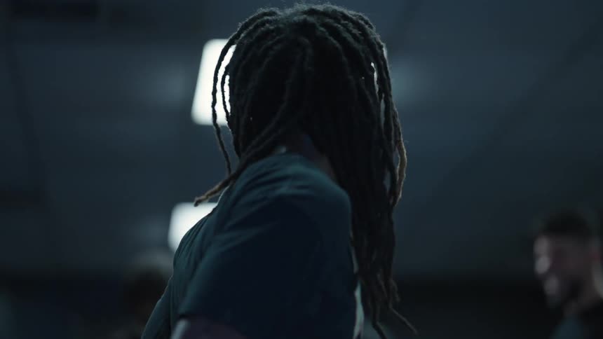 A young man with dreadlocks jumping rope on a gym