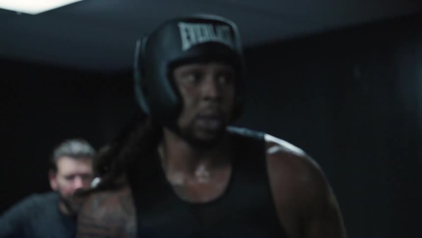 A boxer is punching around in the ring