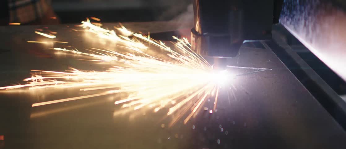 Metalworking machinery in action with bright sparks flying as a tool cuts through metal