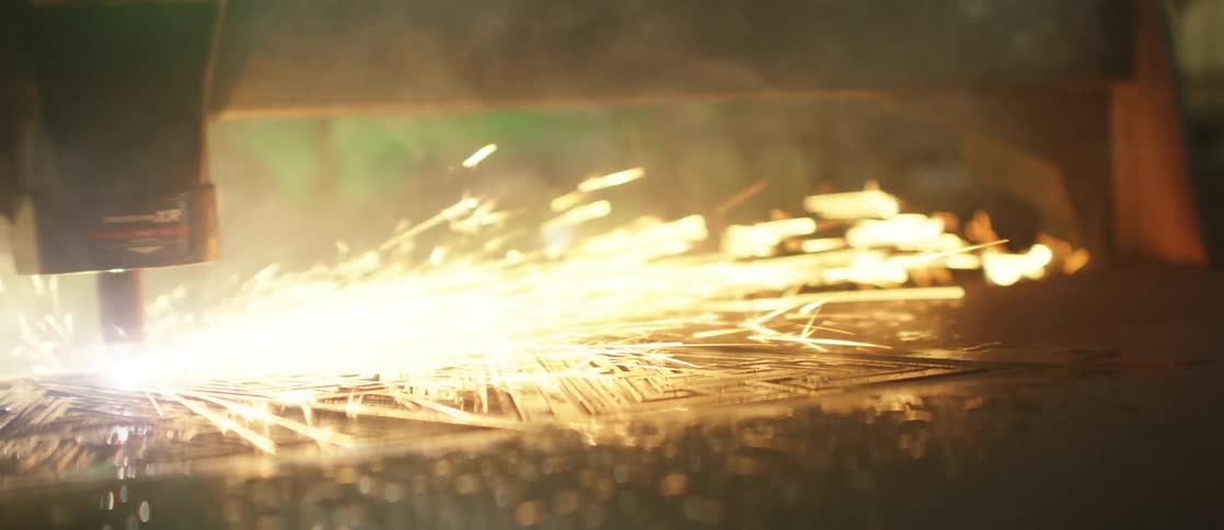 A closeup view of metal being cut or welded with sparks flying from the point of contact