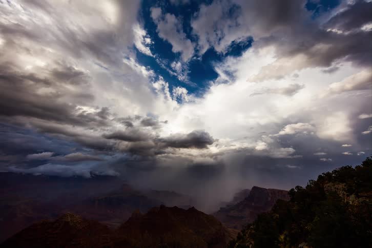Timelapse of a dramatic landscape with dark rugged mountains under bright and dark storm clouds