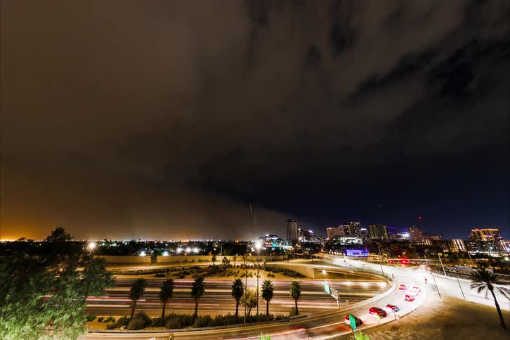 Timelapse of a dense rainstorm enveloping a city at night