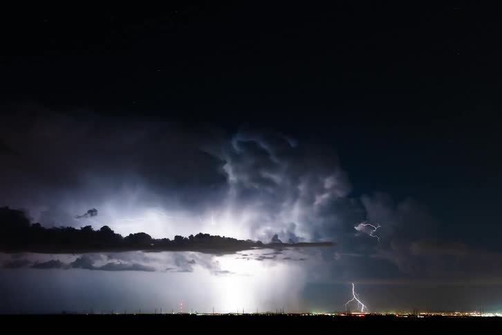Time lapse of an intense thunderstorm passing over a city at night