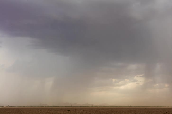 A strong windstorm and lightning striking an empty field