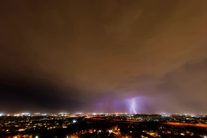 Time lapse of an intense thunderstorm passing over a city at night