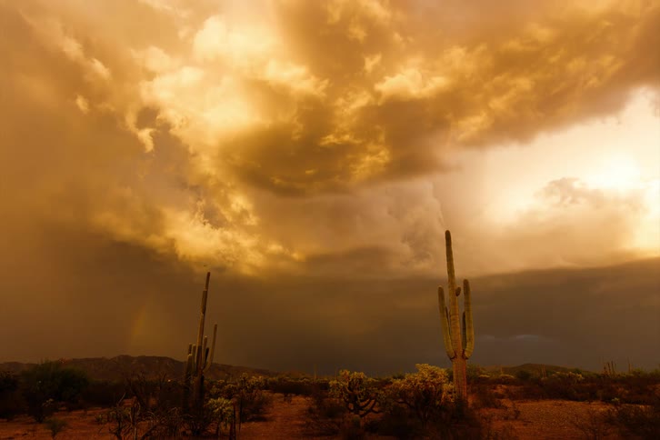 Time lapse of a gust of rain falling over a flat desert landscape
