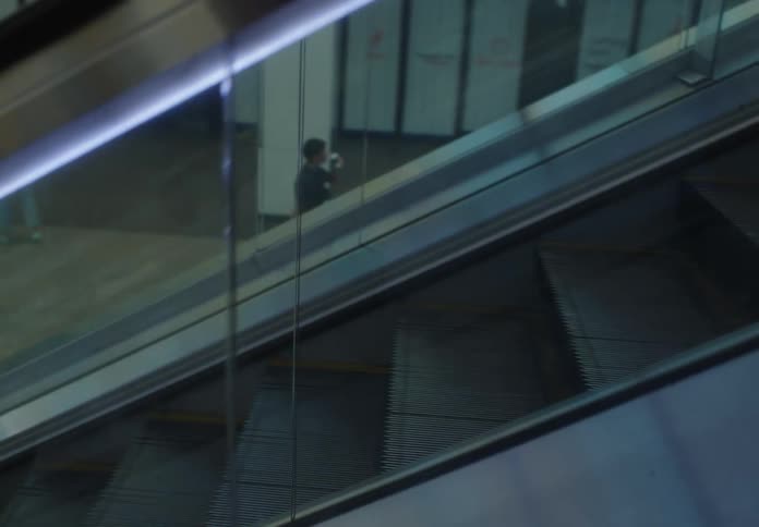 People walking in a building with an escalator