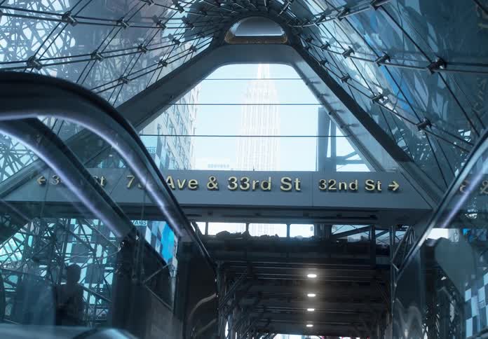 Point of view of a person going up an escalator in Moynihan Pennsylvania train station with Empire State Building in background