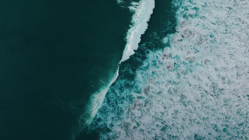 Aerial view of the sea with waves and foam